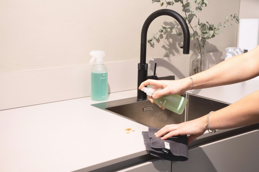 Kitchen sink being scrubbed with a cloth